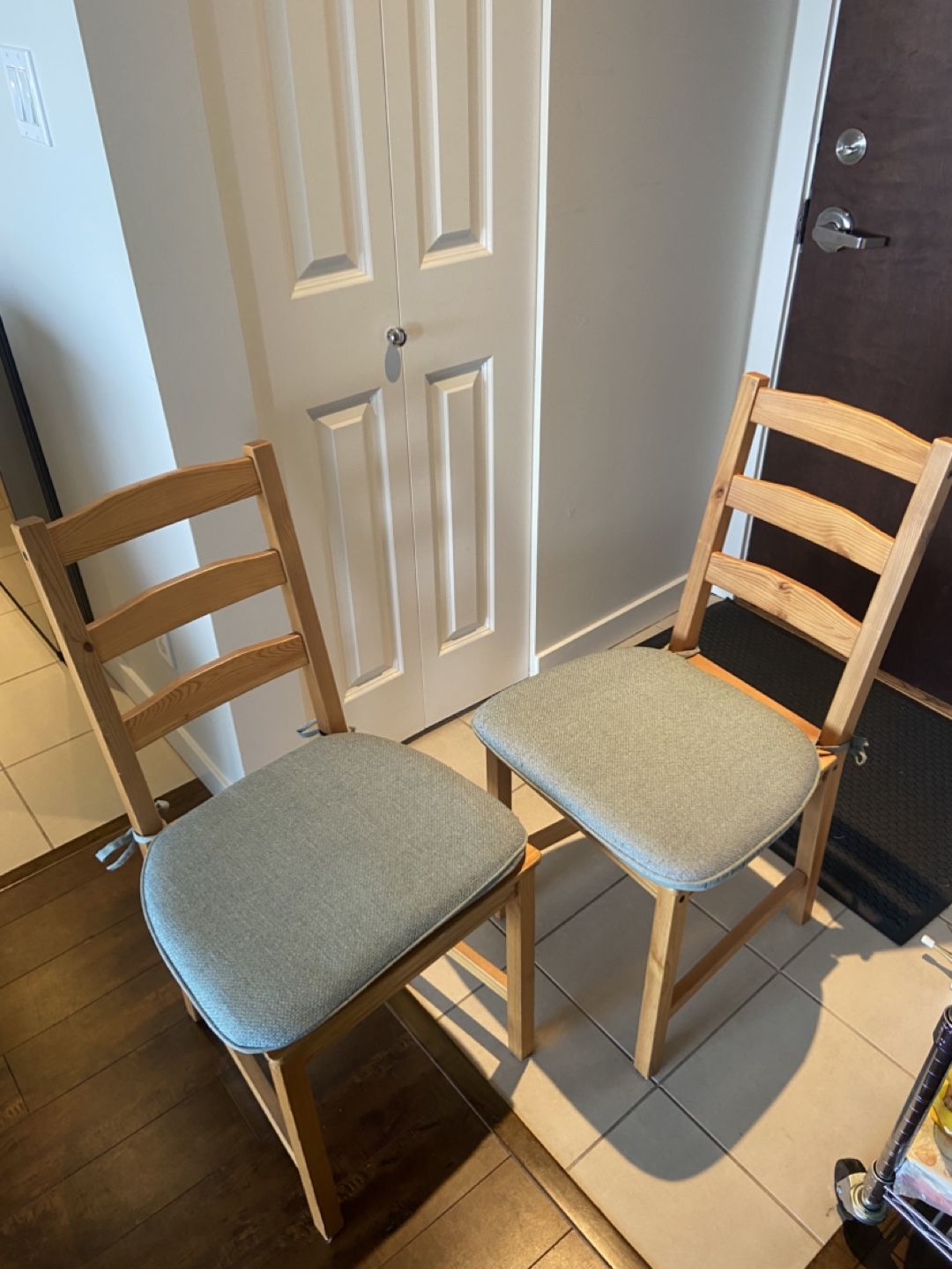 Pair of IKEA wooden chairs with light teal cushions