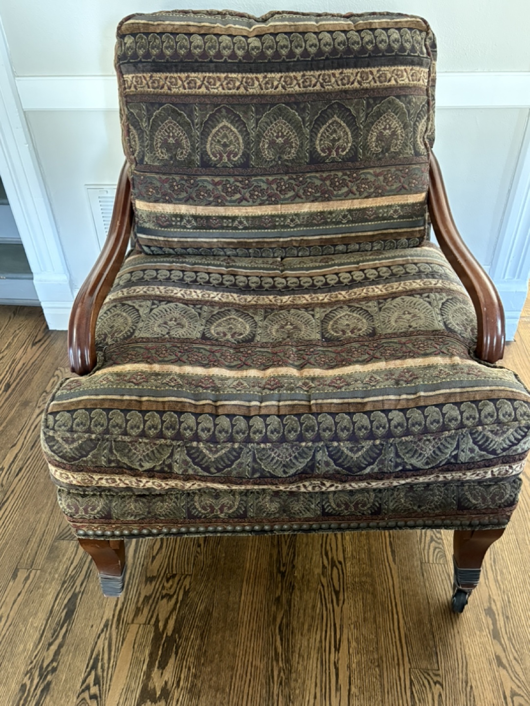 Armchair with patterned upholstery and wooden arms