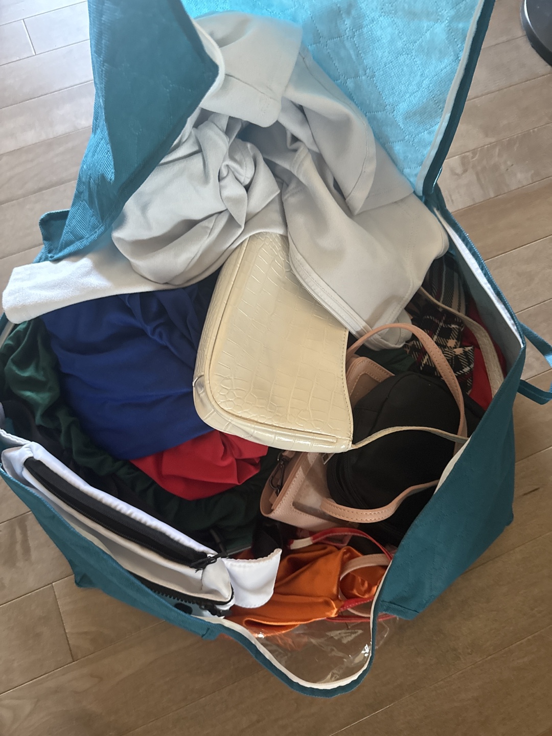 Teal Clothing Storage Bag with Various Items