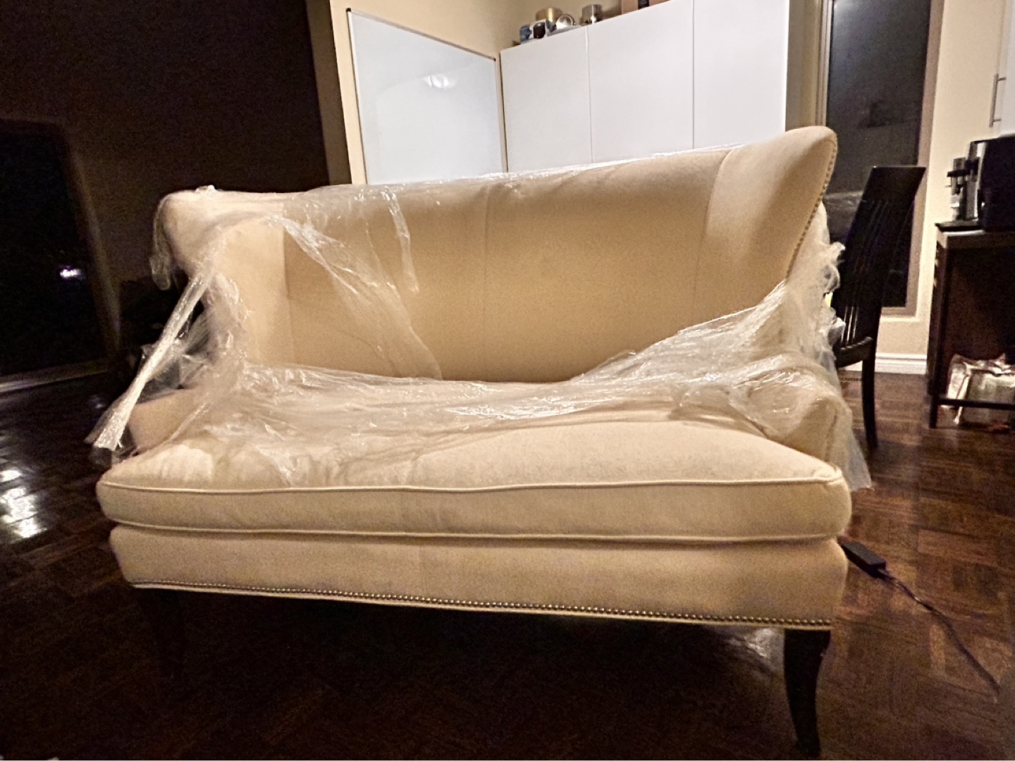 Cream-coloured loveseat with nailhead trim
