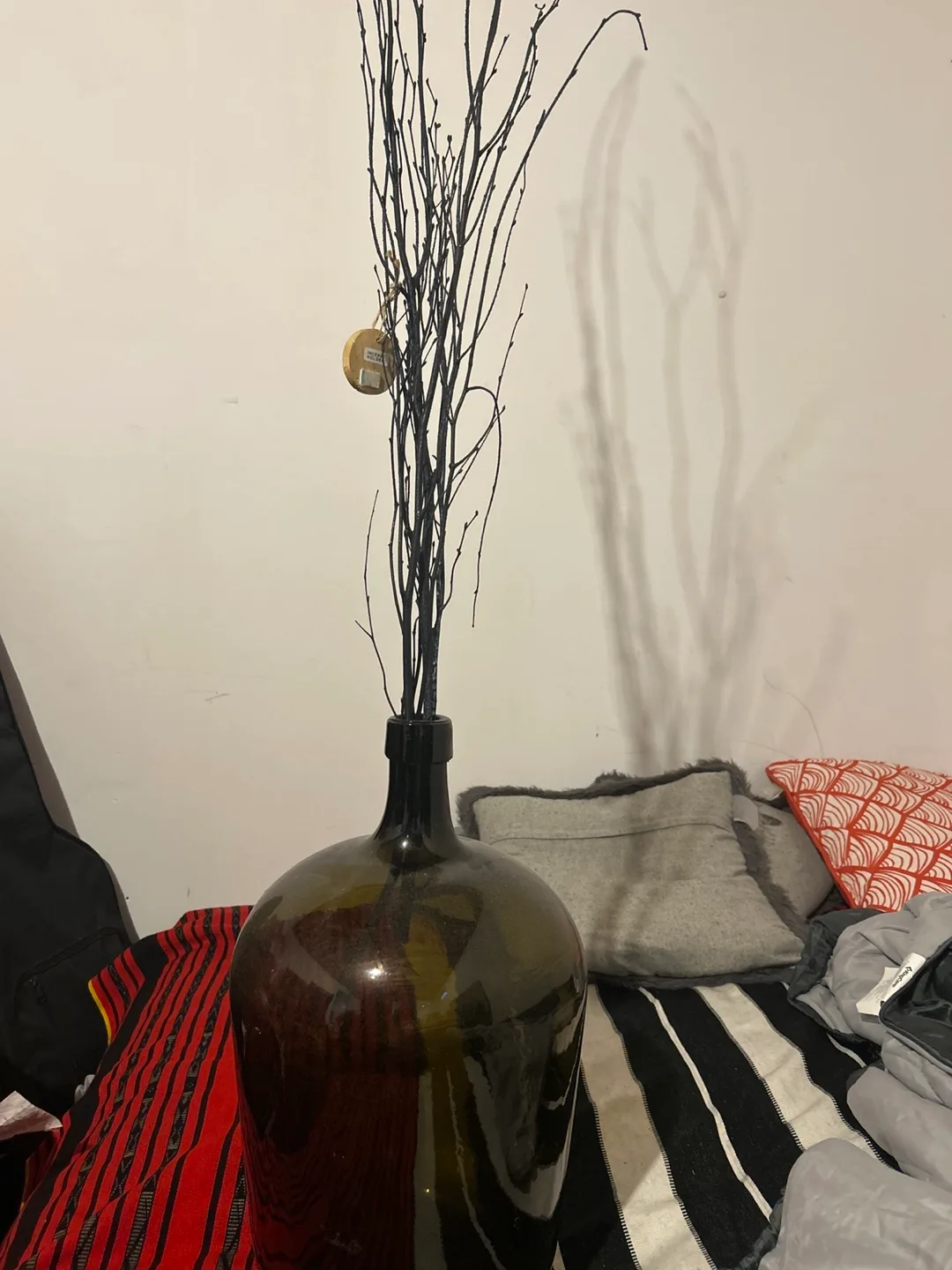 Large dark glass vase with dark branches