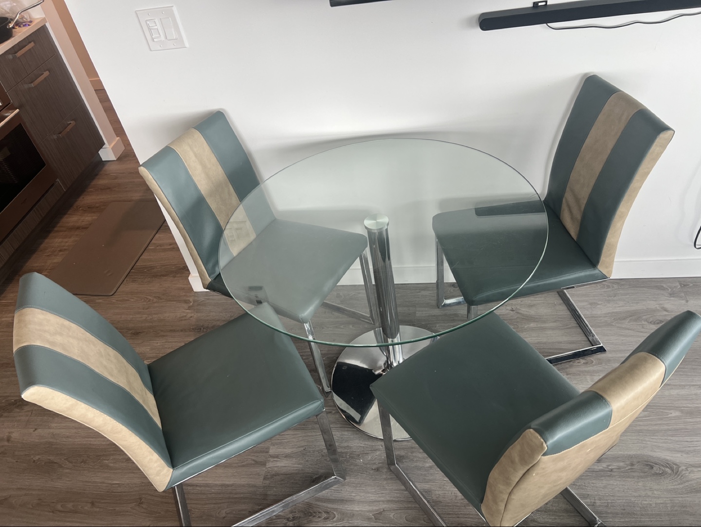 Glass-top dining table with four leather chairs