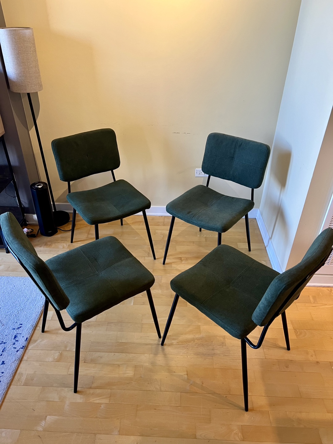 Four Dark Green Upholstered Dining Chairs with Black Metal Legs