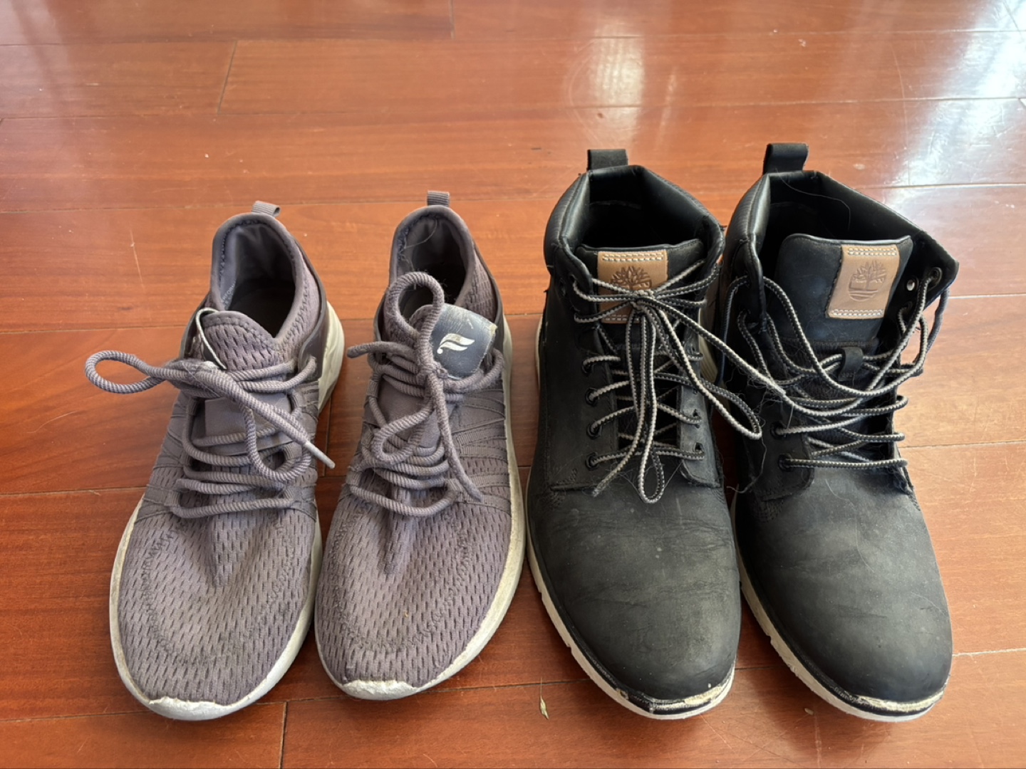 Pair of Grey Running Shoes and Black Timberland Boots
