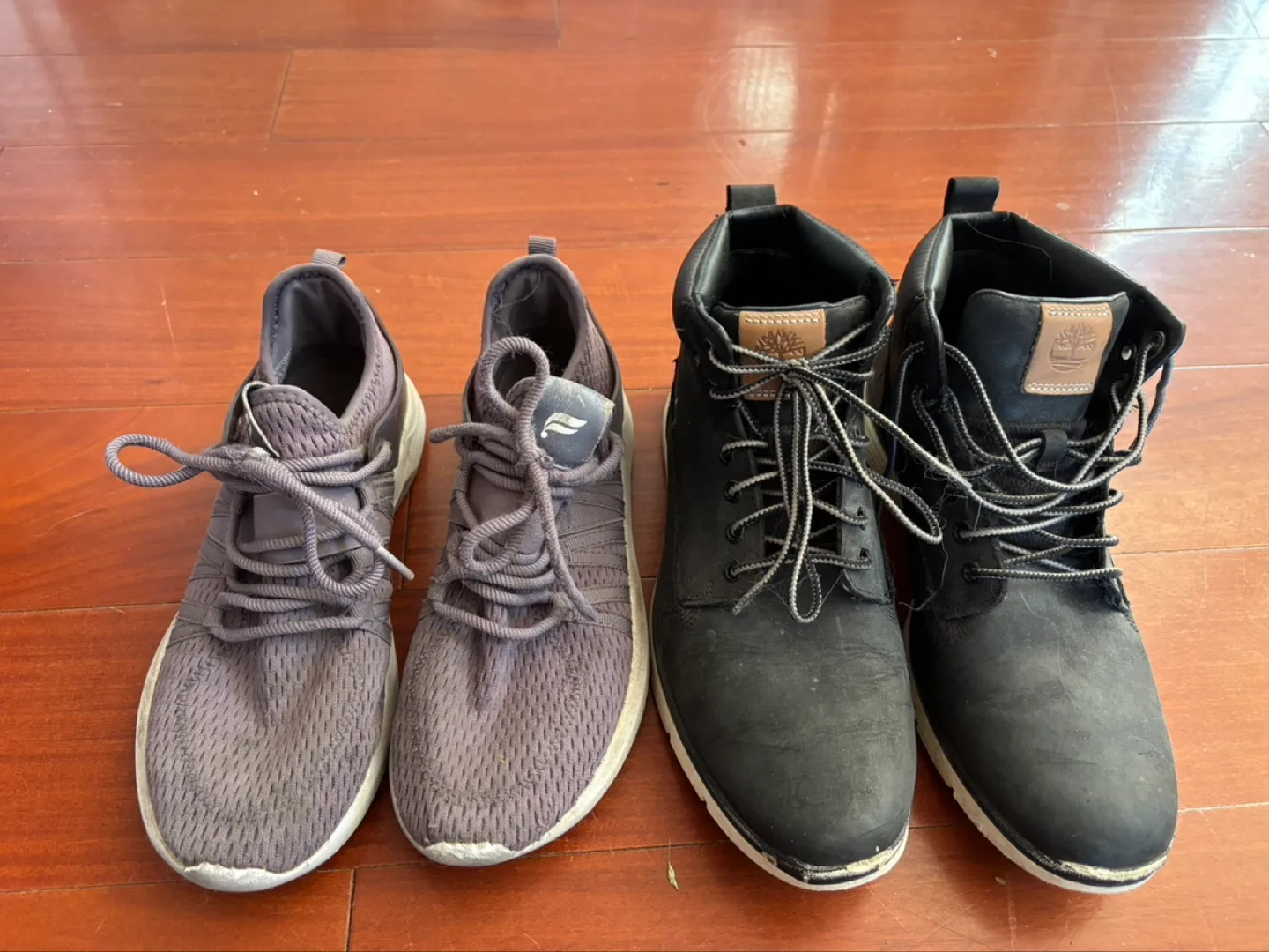 Pair of Grey Running Shoes and Black Timberland Boots thumbnail