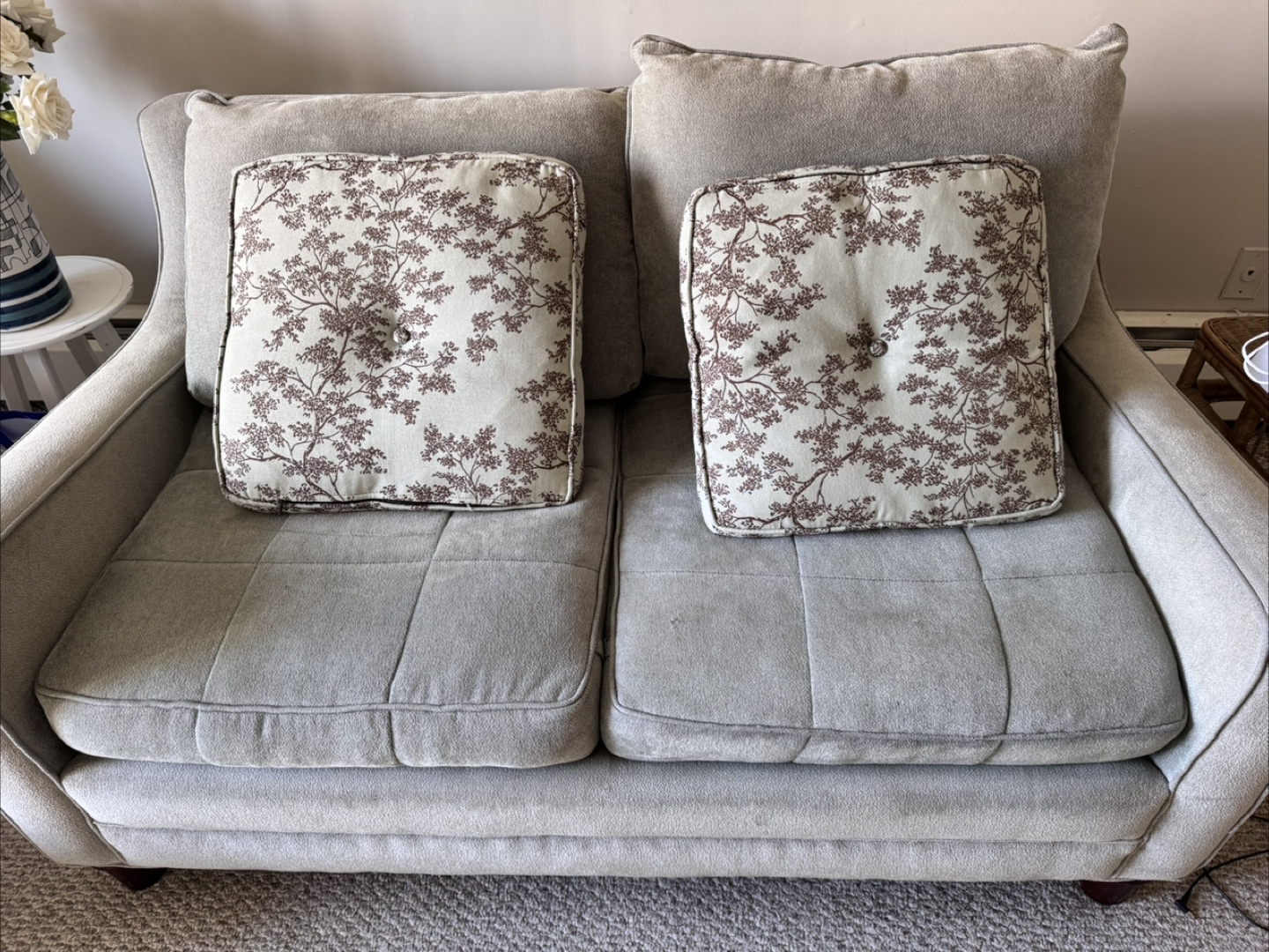 Grey loveseat with patterned cushions