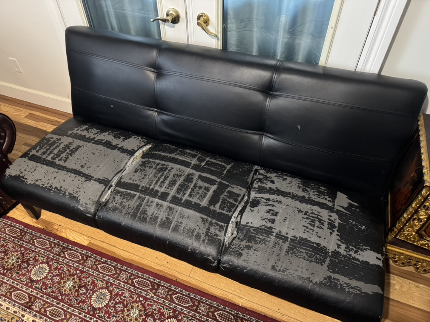 Damaged Black Leather Sofa