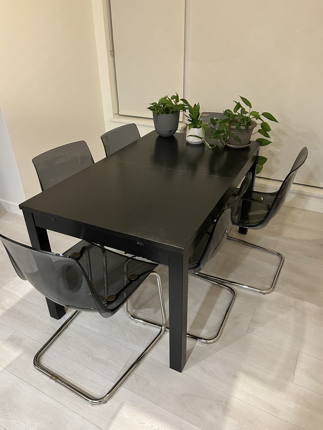 Black dining table and six transparent chairs