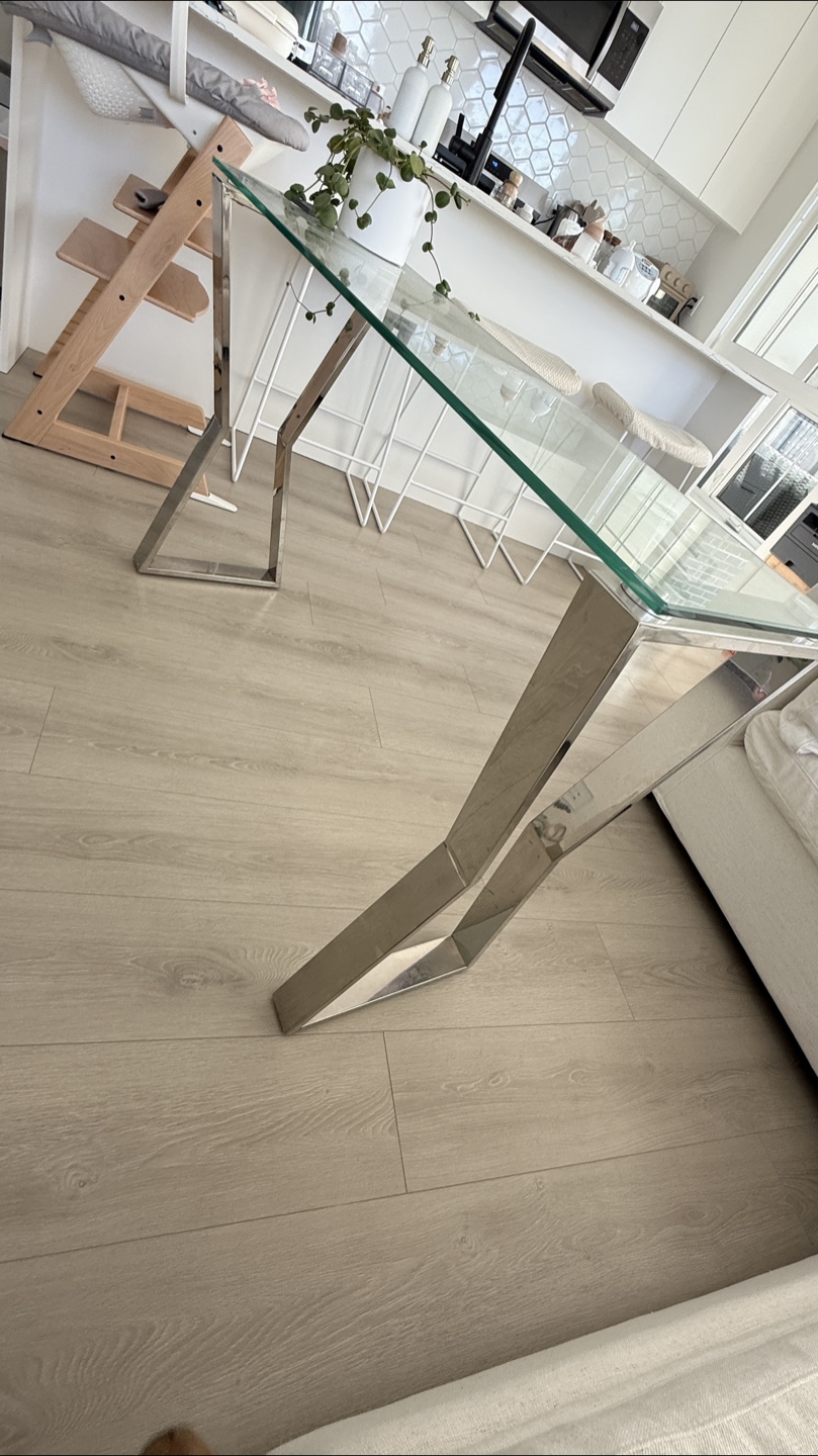 Glass-top console table with stainless steel legs