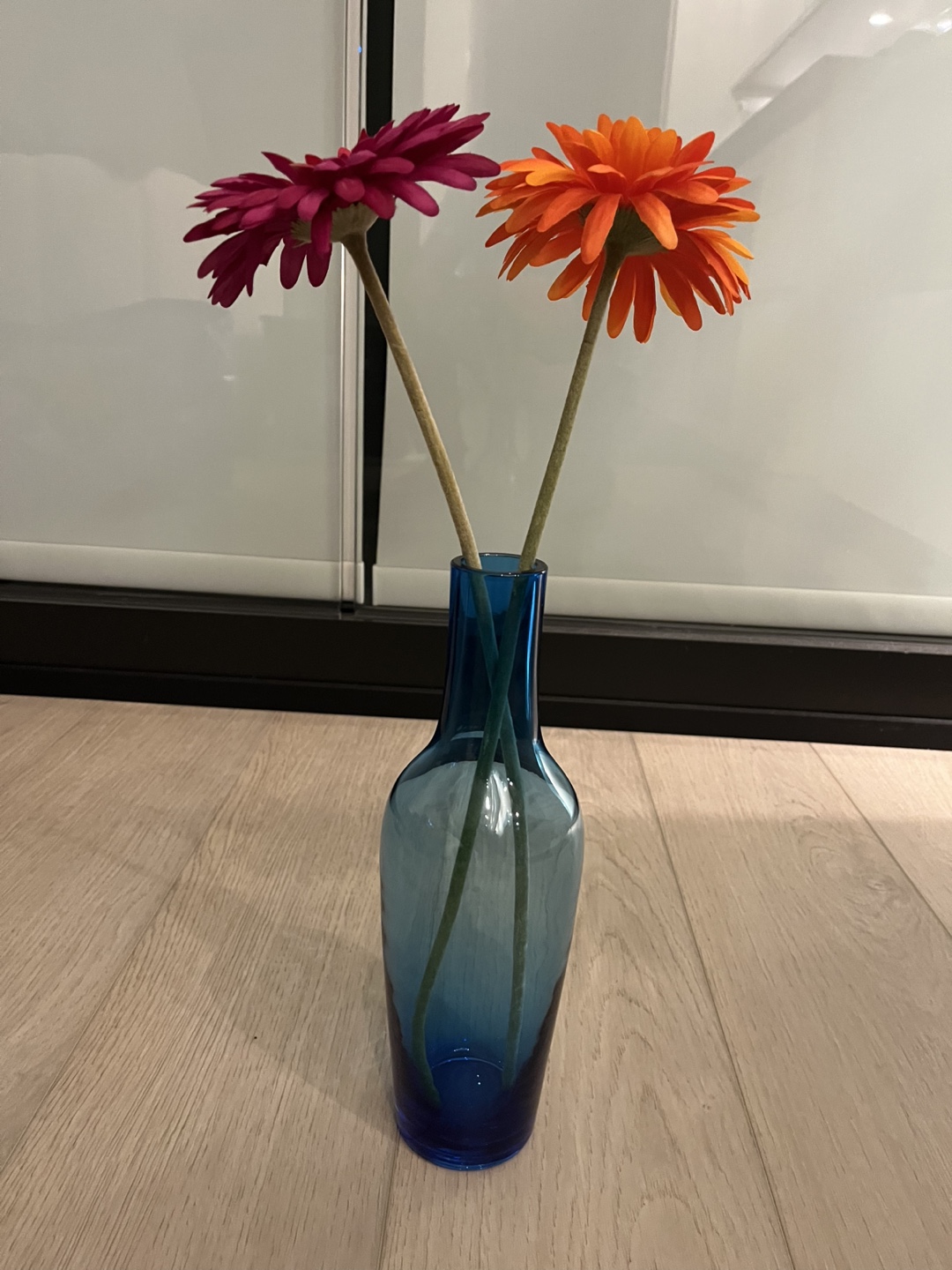 Blue glass vase with artificial flowers