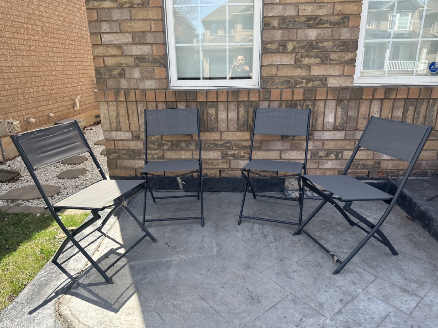 Set of four grey folding patio chairs
