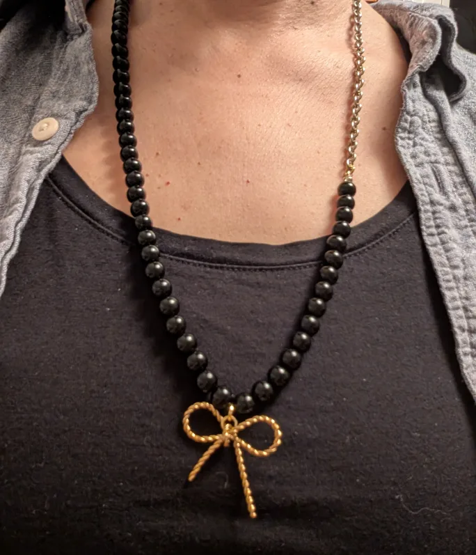 Black beaded necklace with gold bow pendant thumbnail