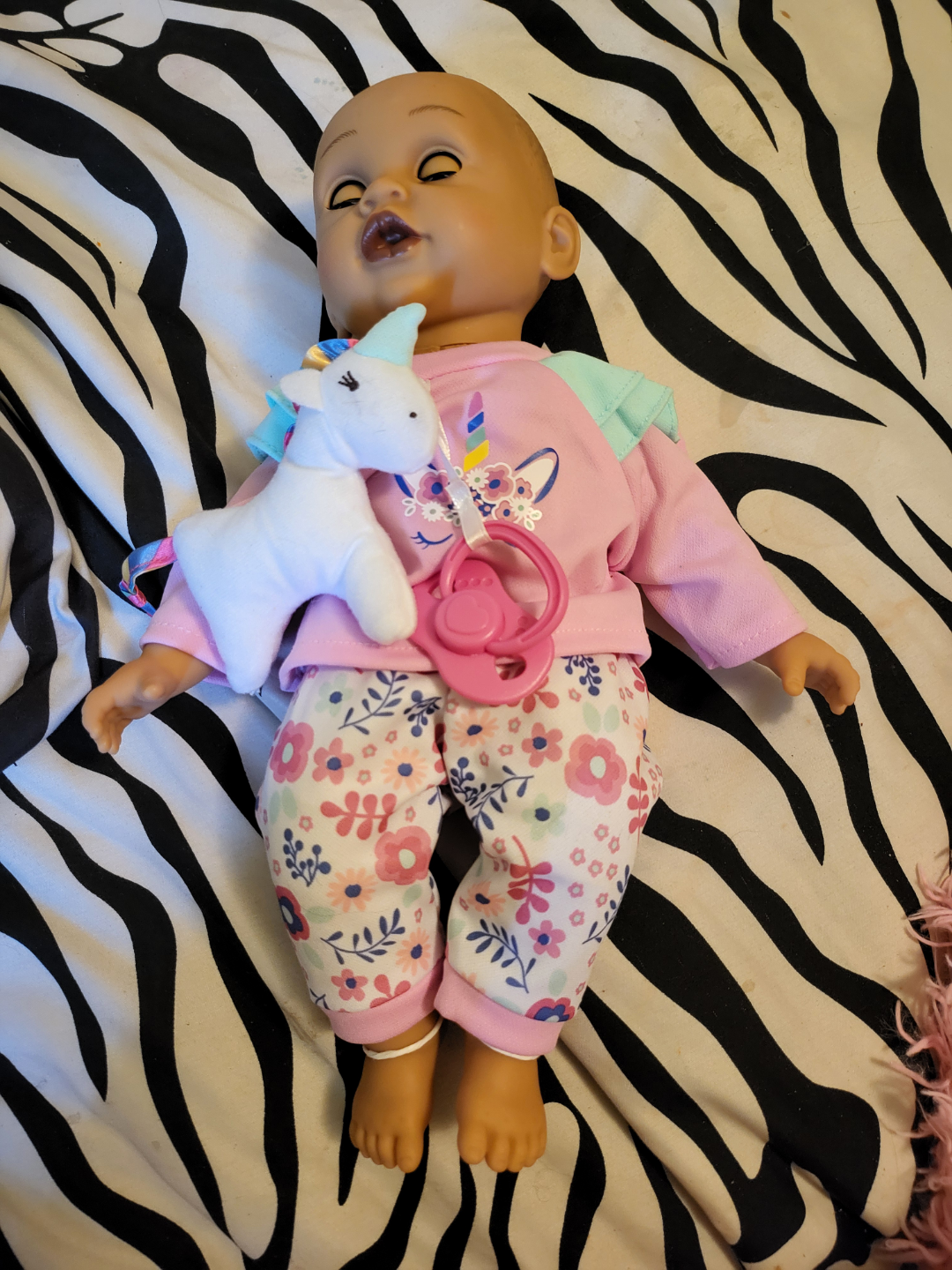 Baby doll with unicorn and pacifier