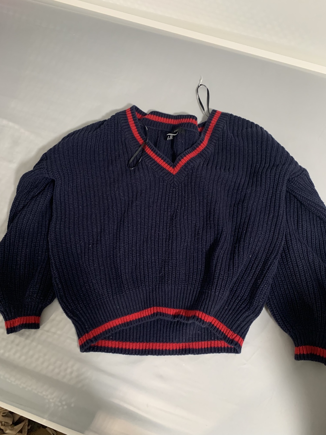 Navy blue V-neck sweater with red stripes