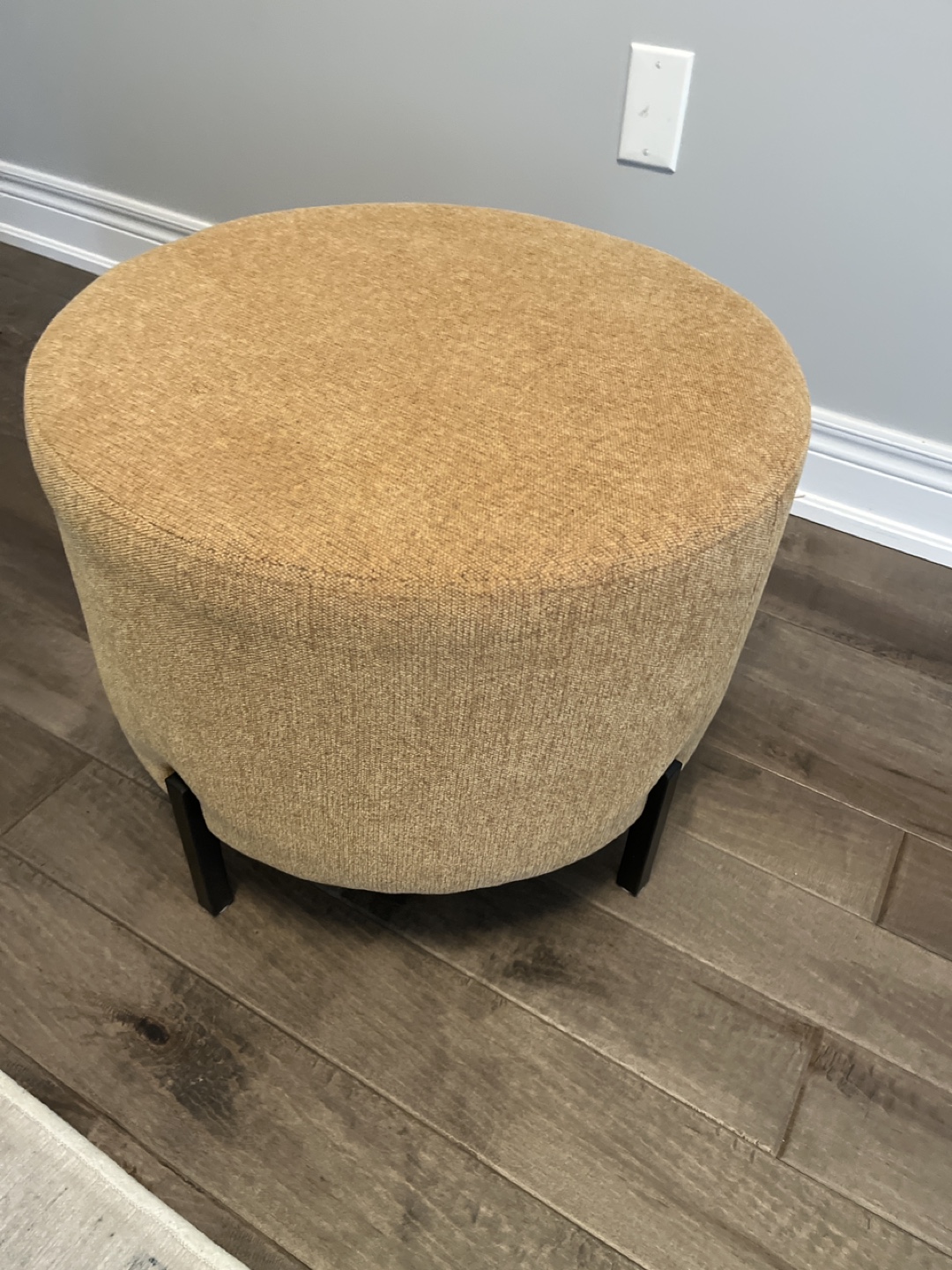 Round Upholstered Ottoman with Black Legs
