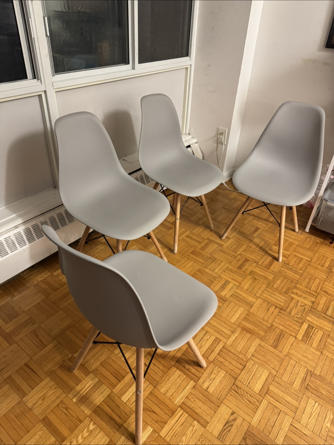 Set of four grey plastic dining chairs with wooden legs