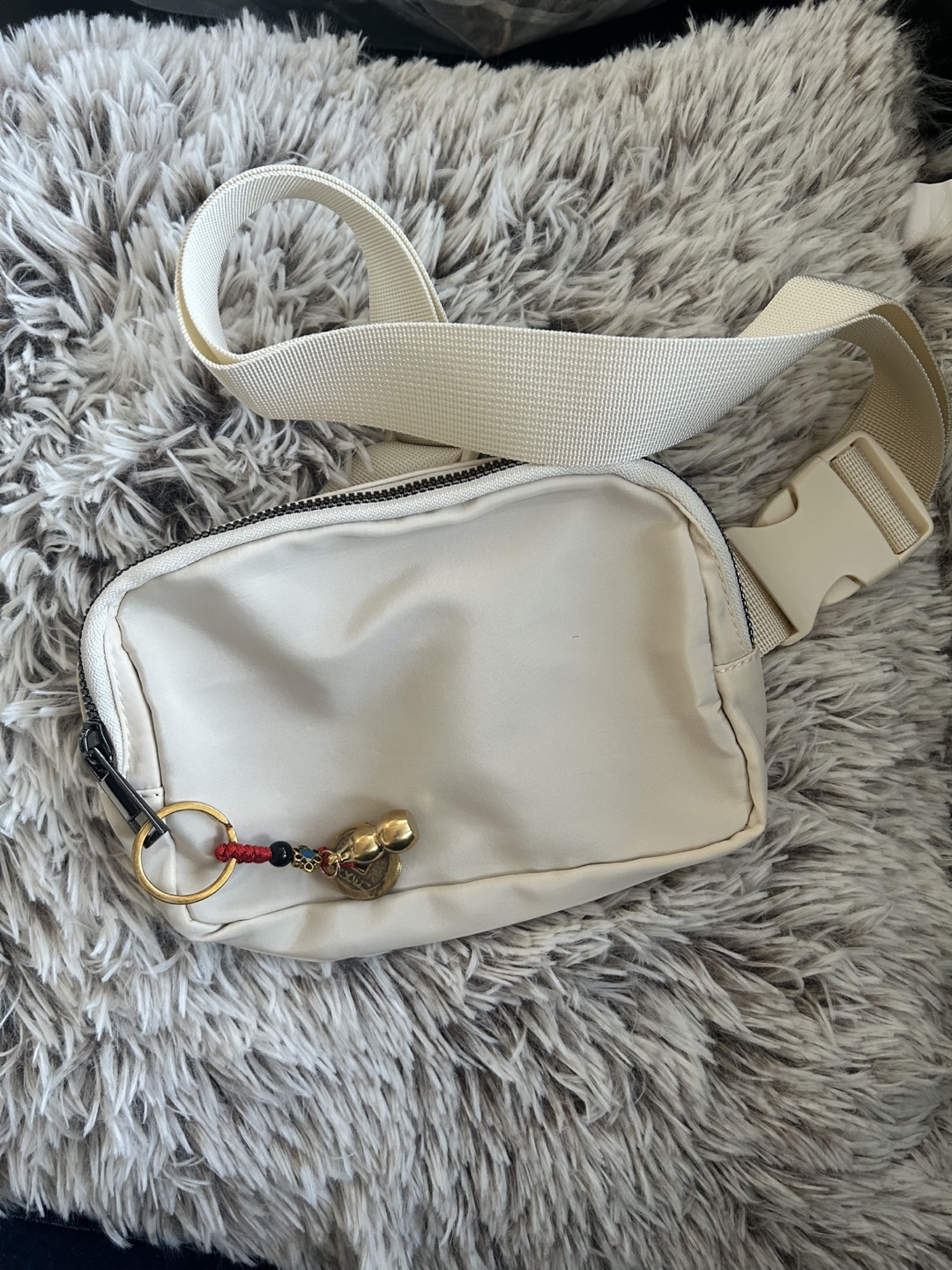 Cream-coloured waist bag with boxing glove keychain