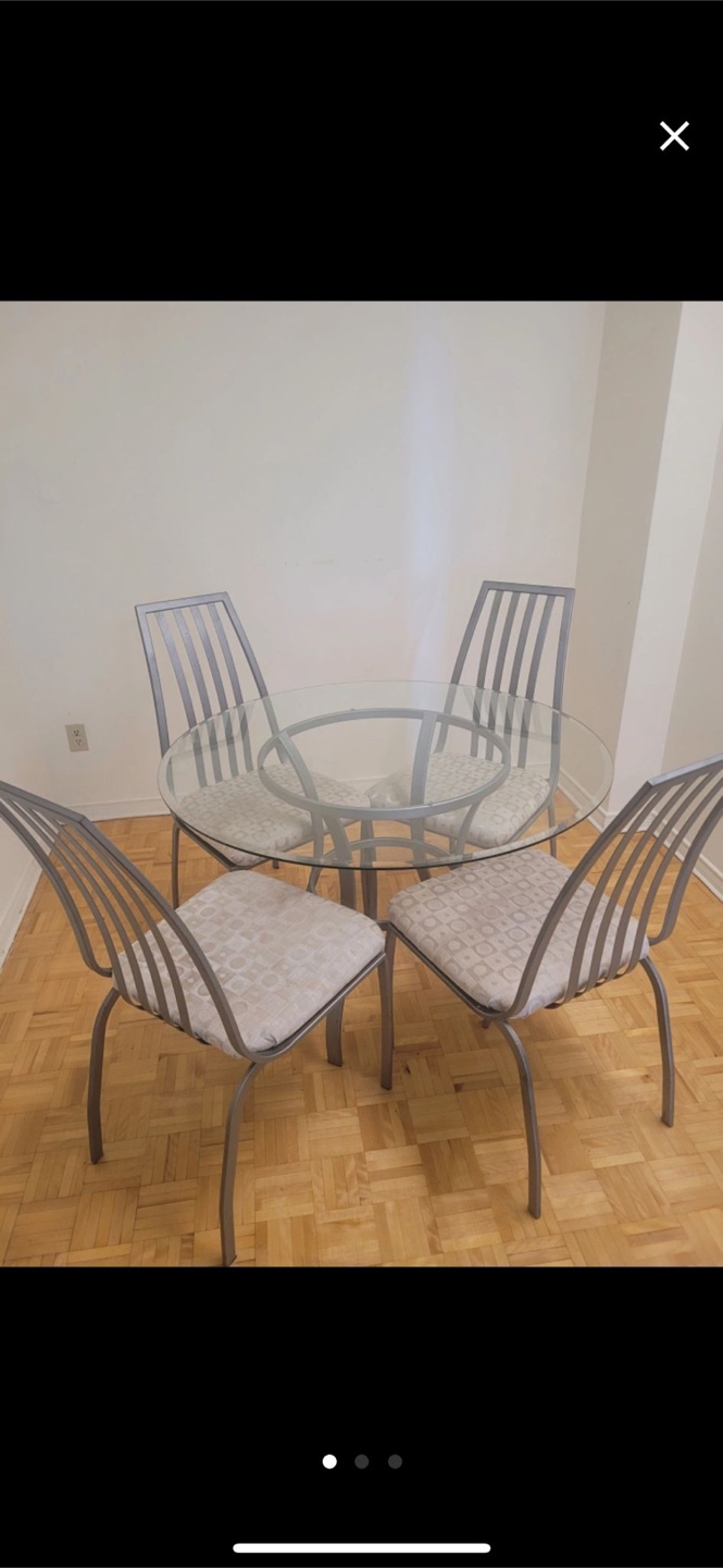 Glass-top dining table with four chairs