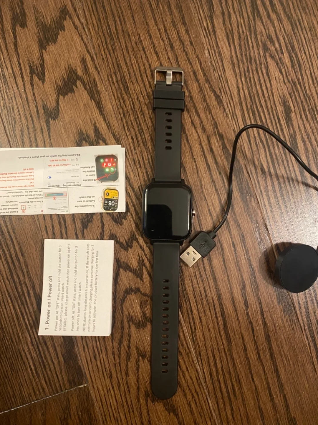 Smartwatch with USB charging cable and user manual image indicator(2)