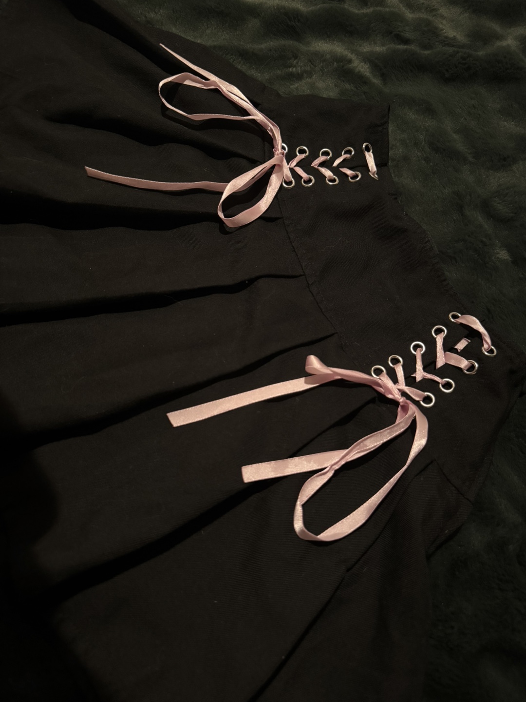 Black pleated mini skirt with lace-up detail and ribbons