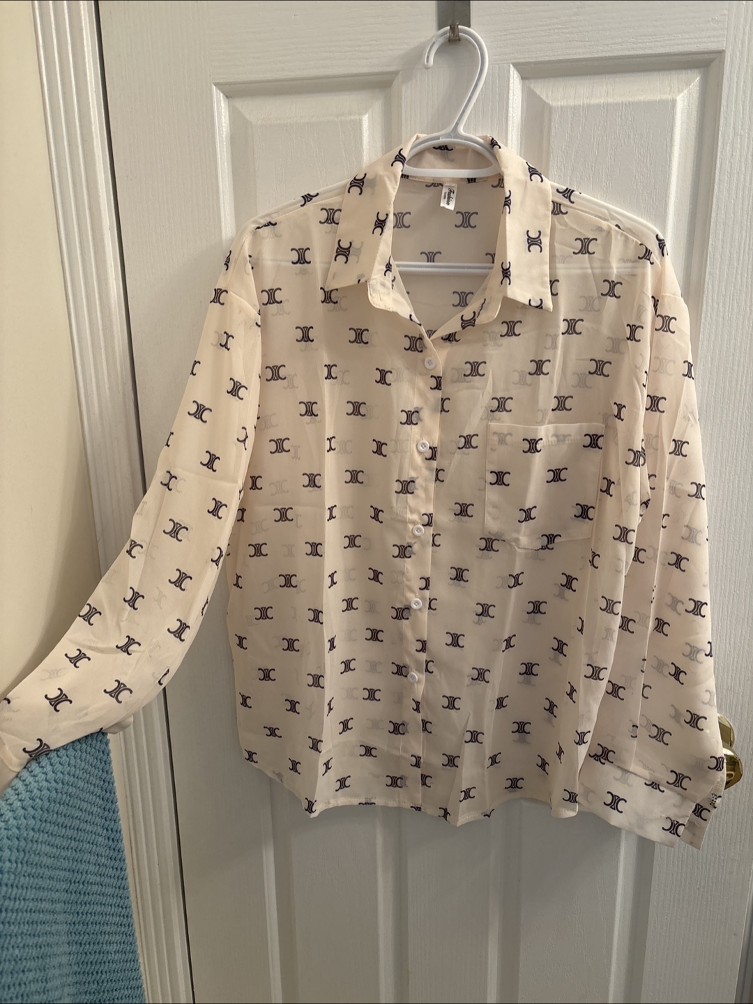 Cream-coloured button-up blouse with repeating logo print