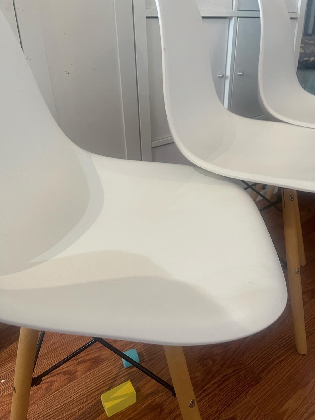 Set of three white plastic chairs with wooden legs - photo 2