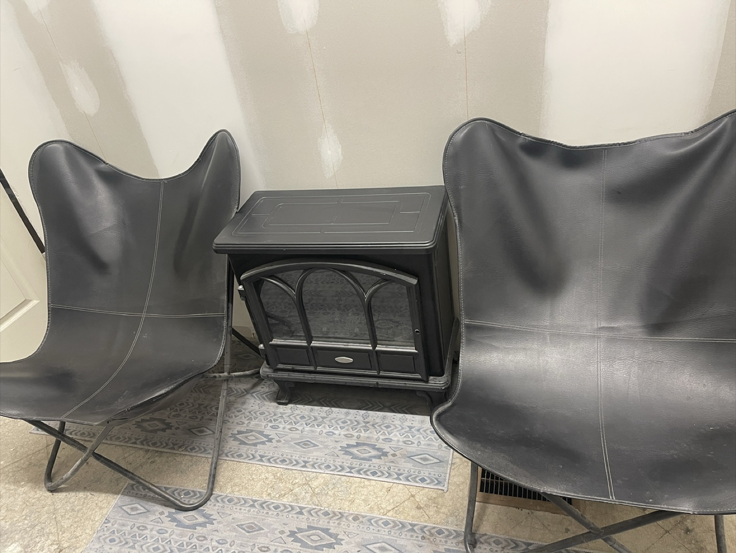 Two Black Butterfly Chairs and Electric Fireplace