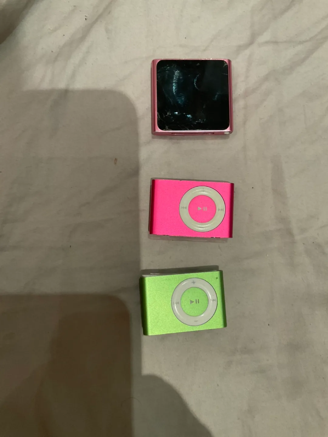 Two iPod Shuffles, pink and green, last-series pink iPod Nano thumbnail