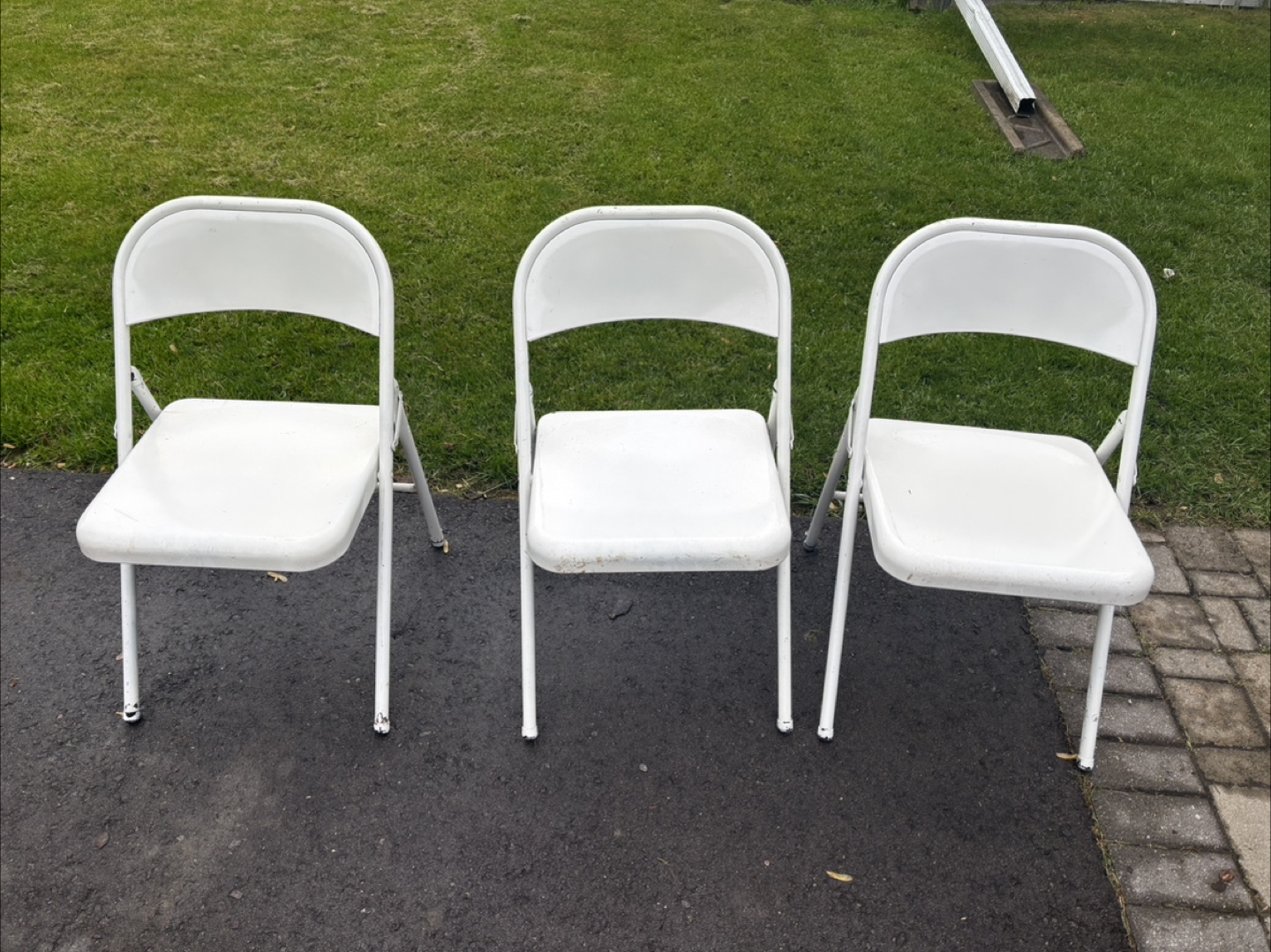 Three White Metal Folding Chairs
