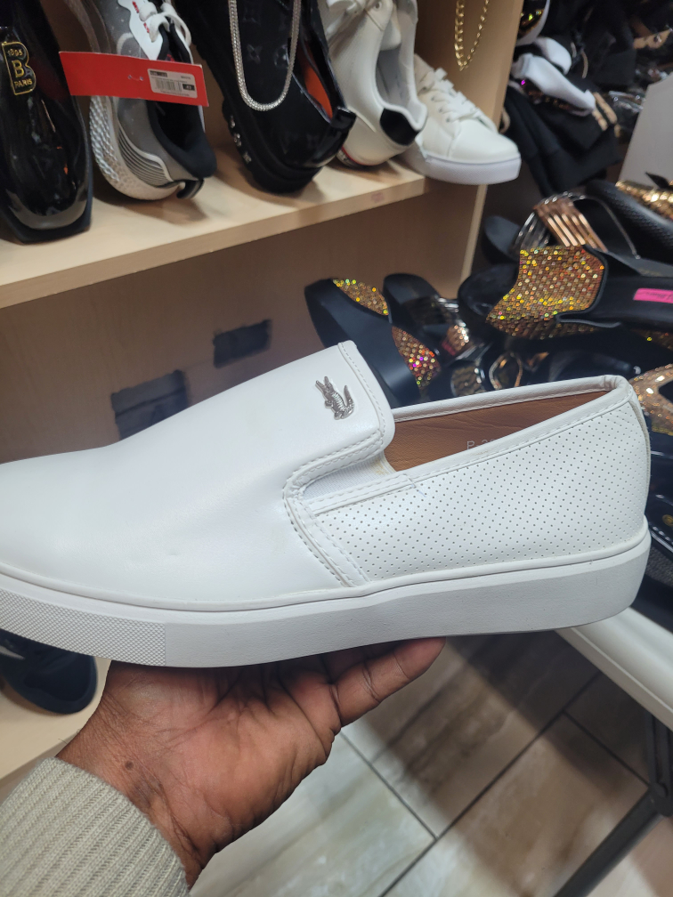 White Lacoste-style slip-on shoes