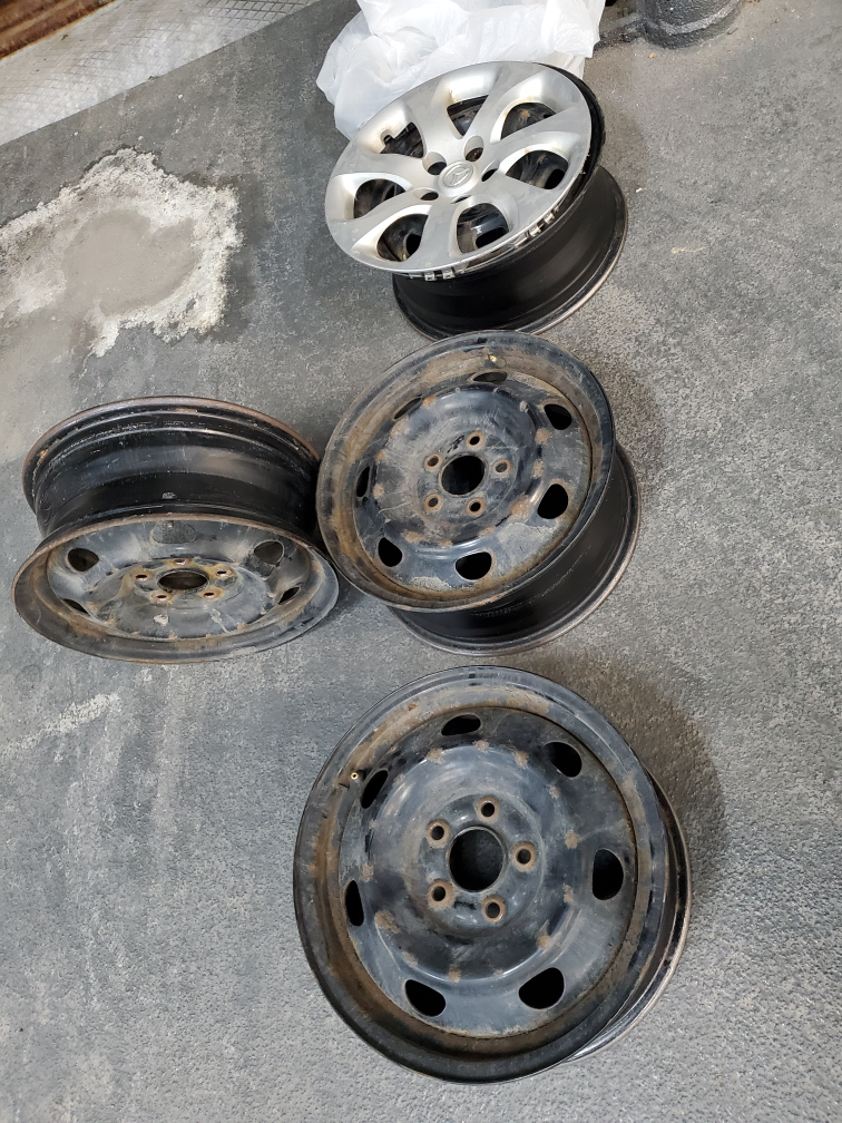 Four steel rims and 4 Mazda plastic hubcaps