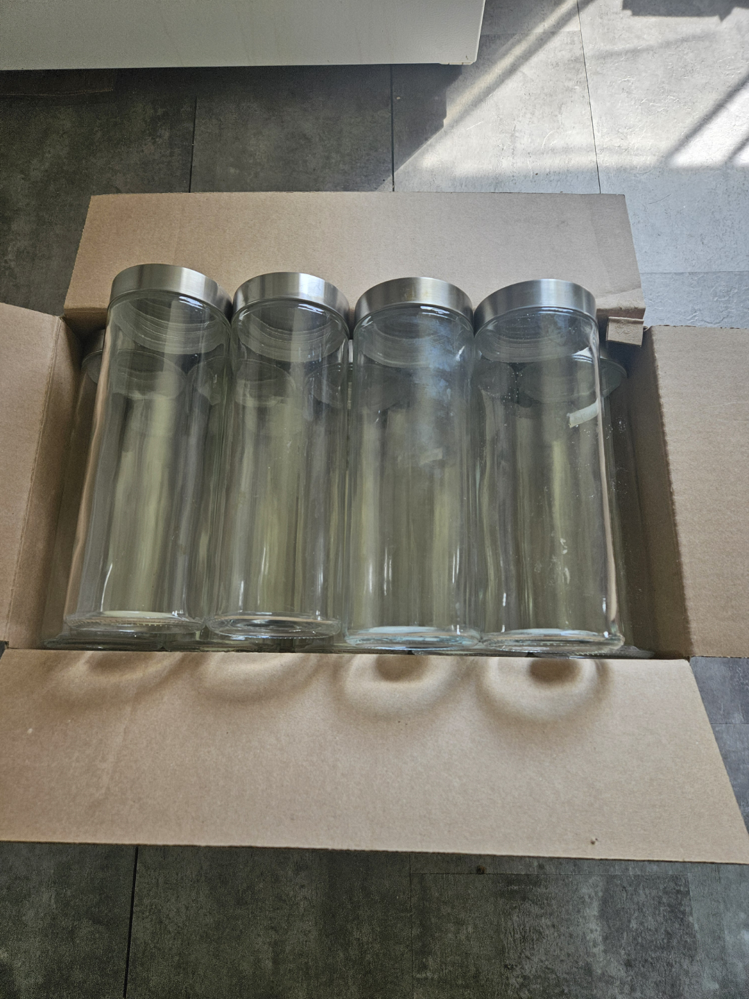 Set of four glass canisters with silver lids