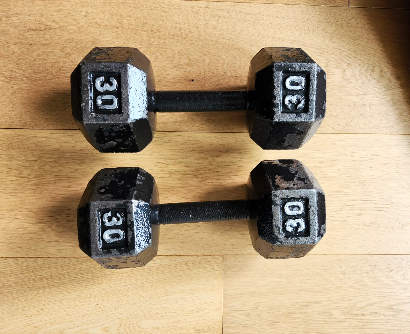 A pair of Amazon Basics Cast Iron 30 lb Hex Dumbbells. thumbnail