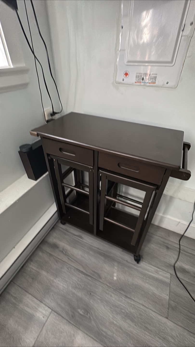 Brown kitchen island with fold out table and two stools