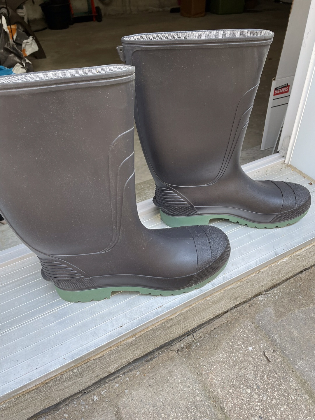 Black rubber boots with green soles