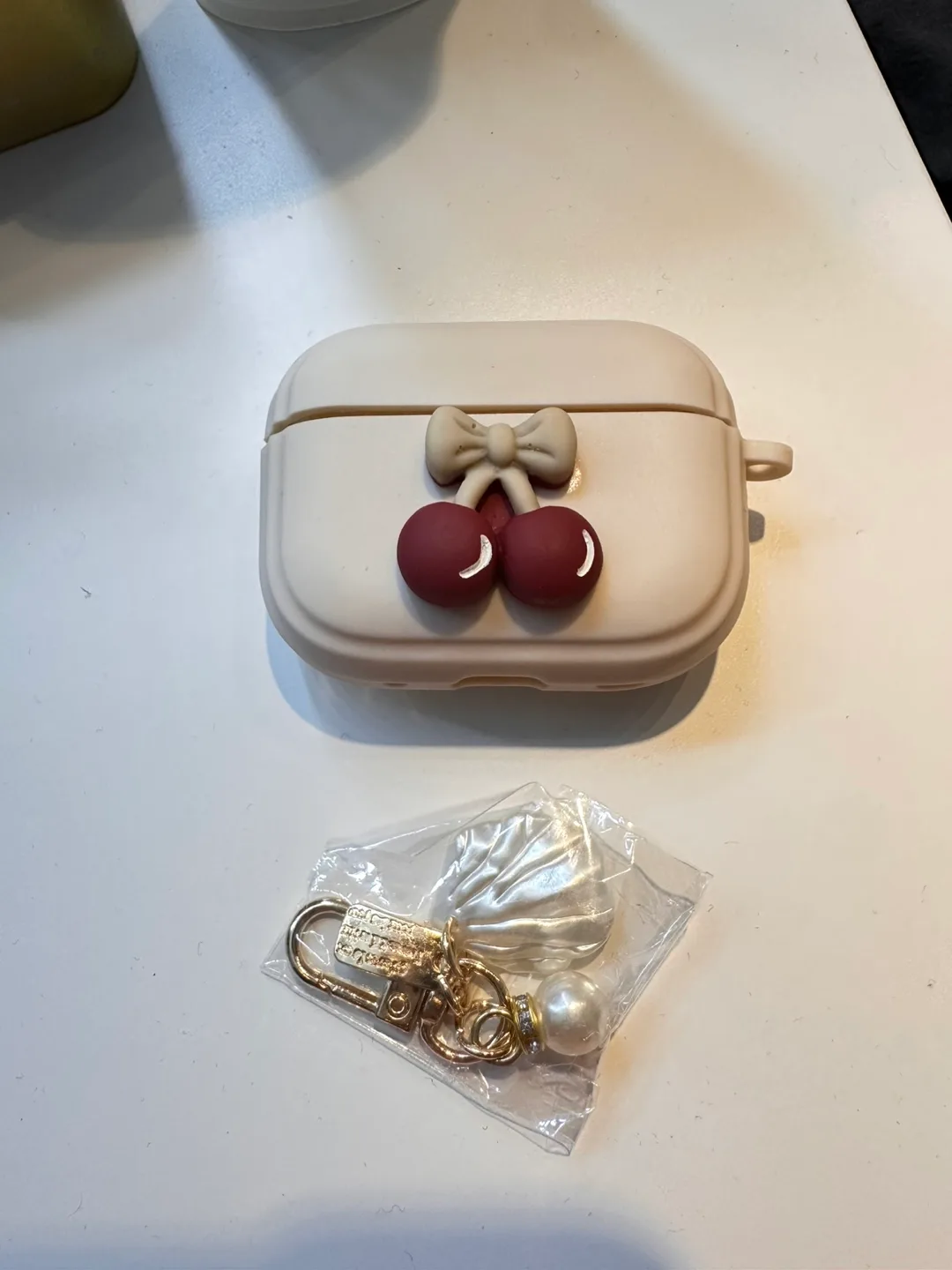 Beige Airpod Case with Cherry Decor and Keychain Set thumbnail