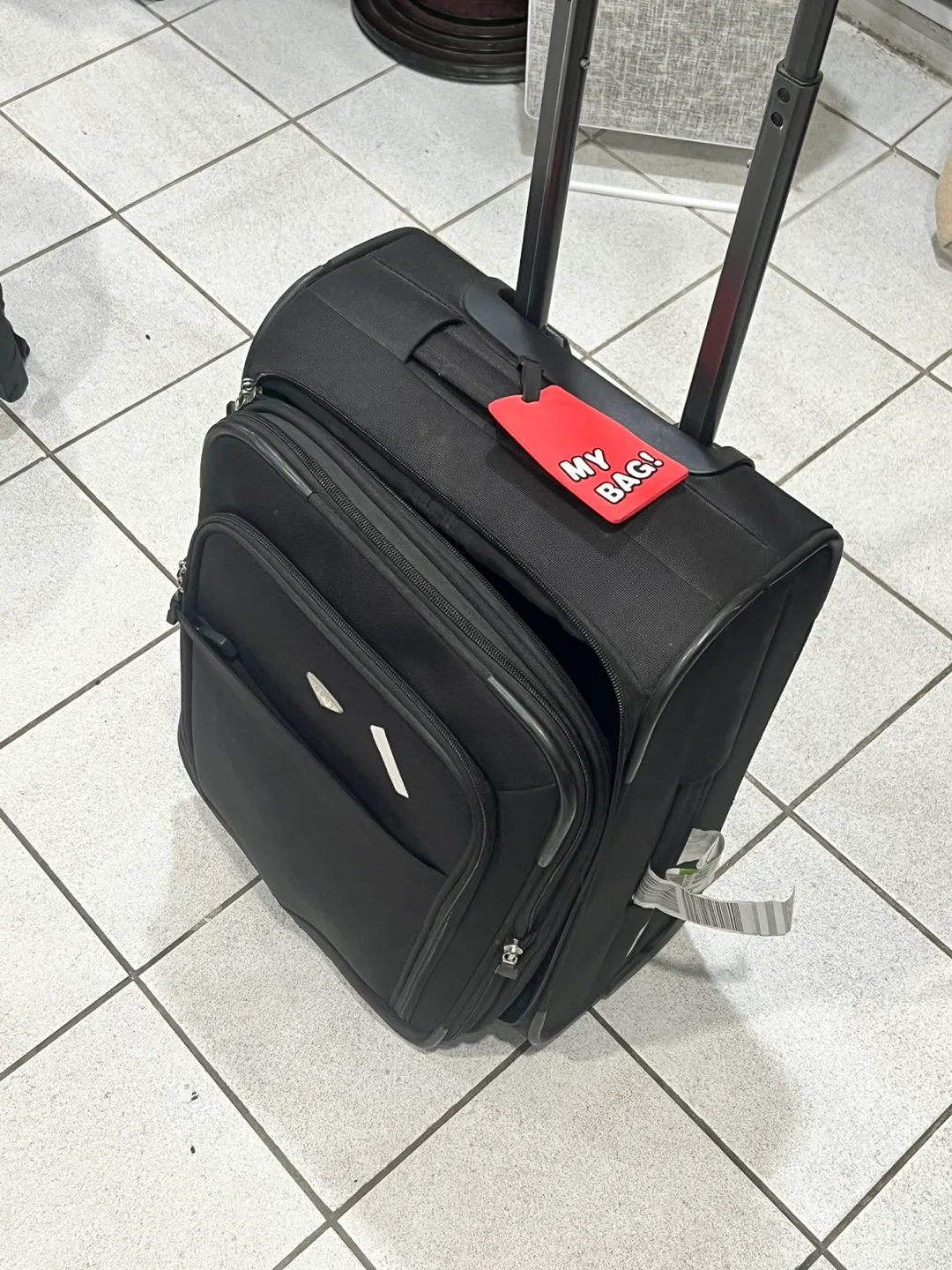 Black Rolling Suitcase with Red Luggage Tag thumbnail