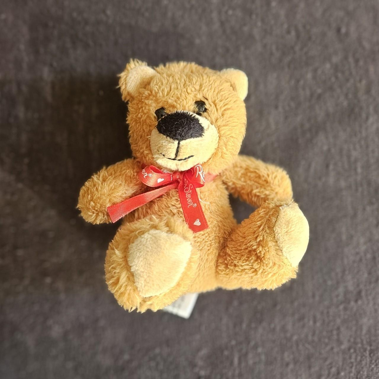 Tan teddy bear with red bow