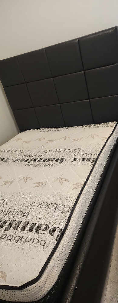 Double size upholstered bed frame with a mattress