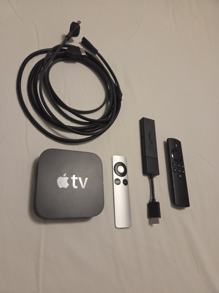 Apple TV with remote and cables and Amazon Fire Stick