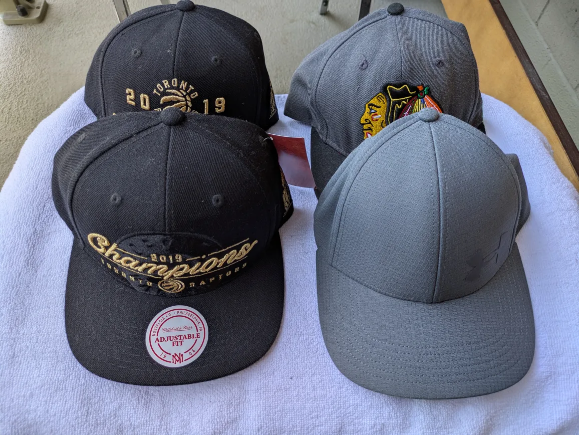 Assorted Baseball Caps: Blackhawks, Raptors, Under Armour thumbnail
