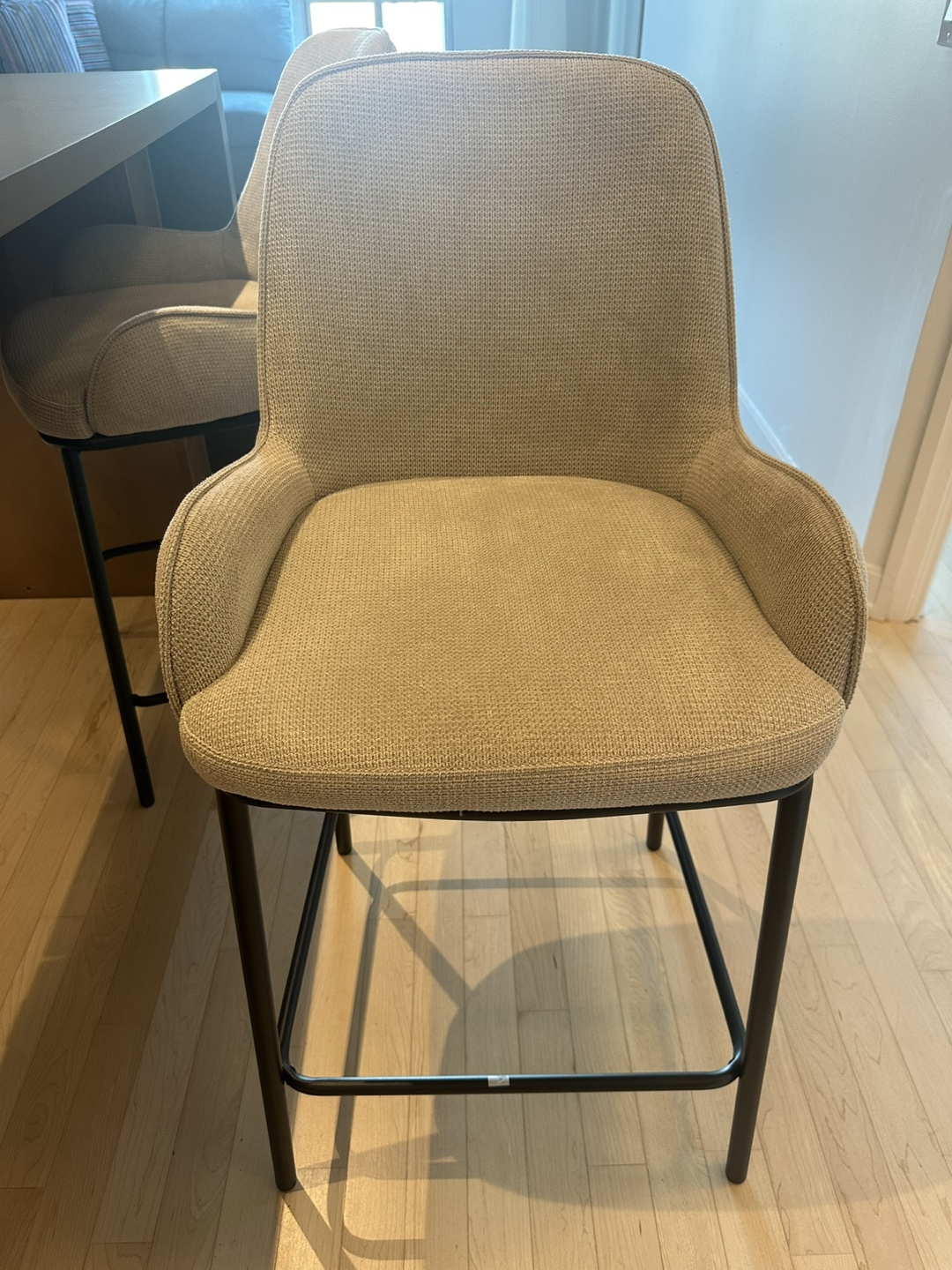 Two Beige Counter Stools with Black Legs