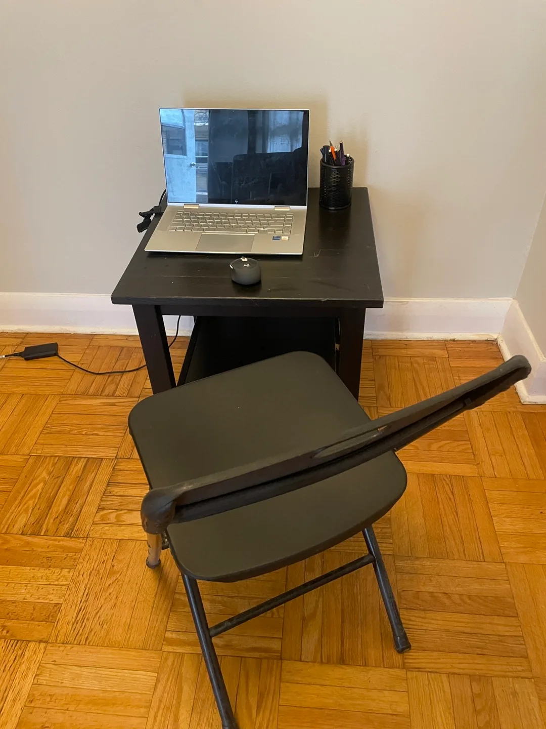 Black corner table with a folding chair. thumbnail