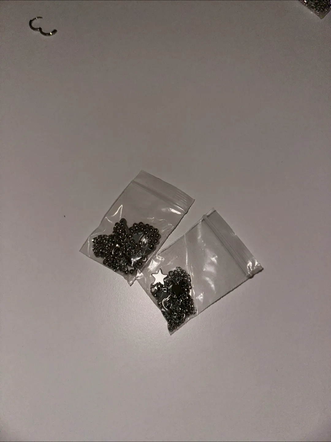 Two bags of metal necklaces and star charms thumbnail