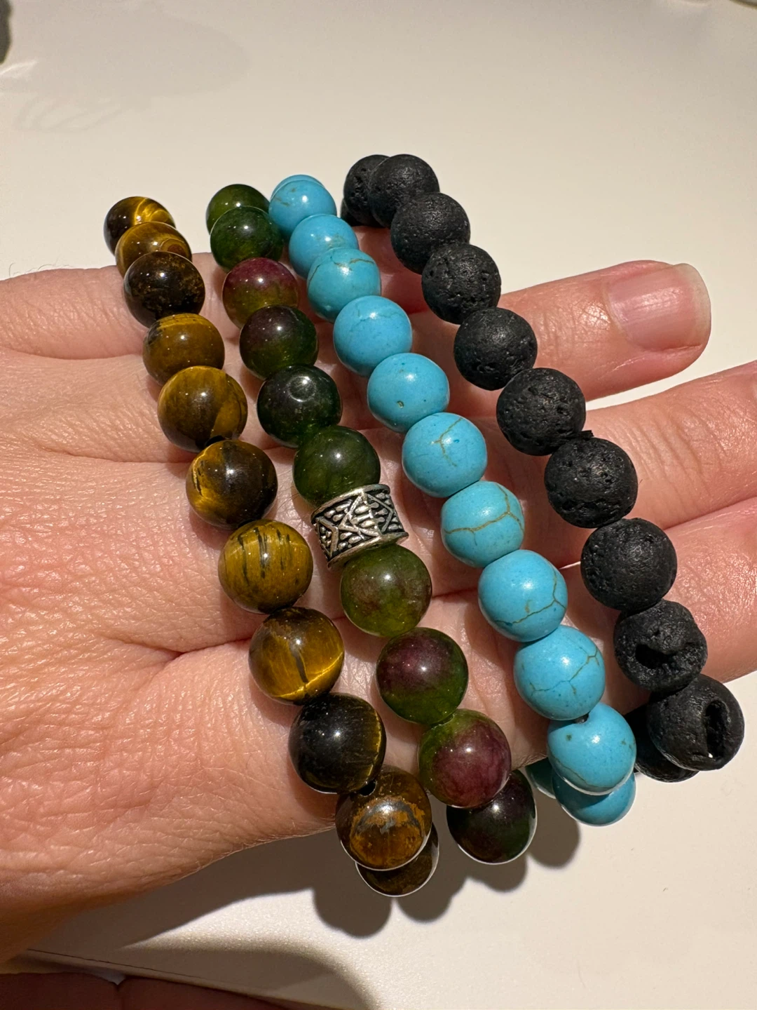 4 bracelets and a jar of mixed pendants and necklaces