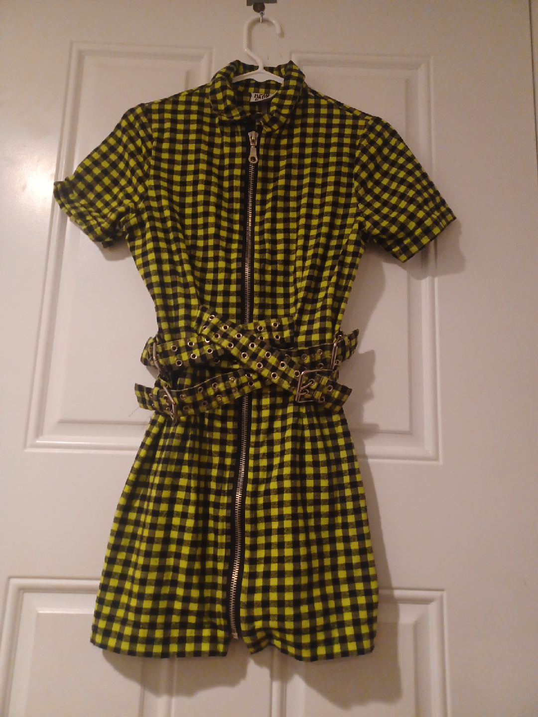 It features a yellow and black plaid pattern and a zipper