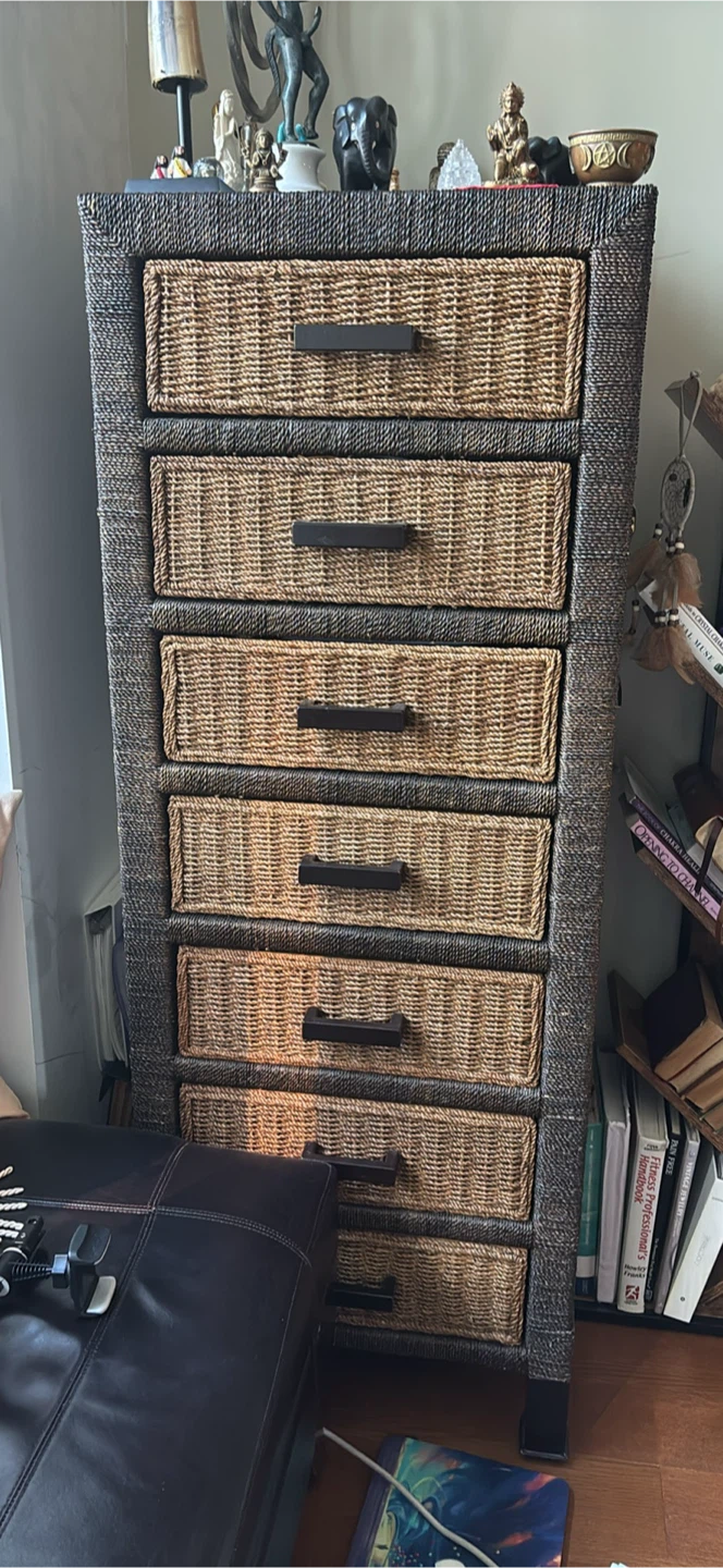 Solid wood dresser wrapped with solid wicker on the outside .