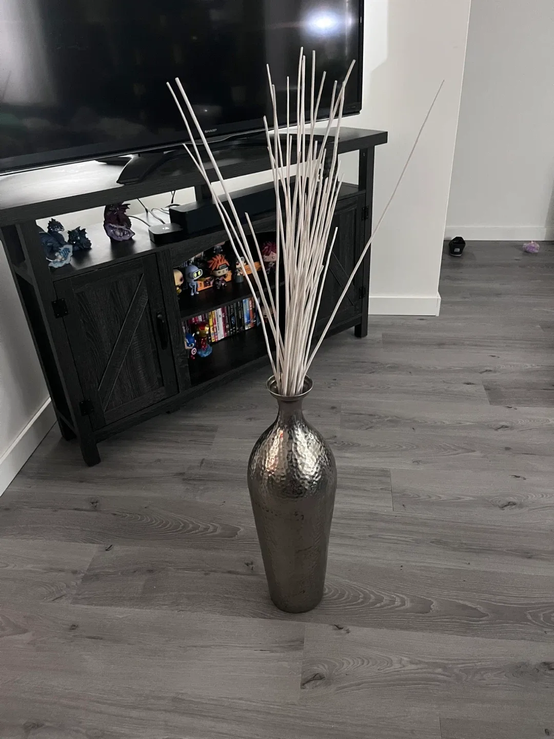 Hammered silver decorative vase with white sticks
