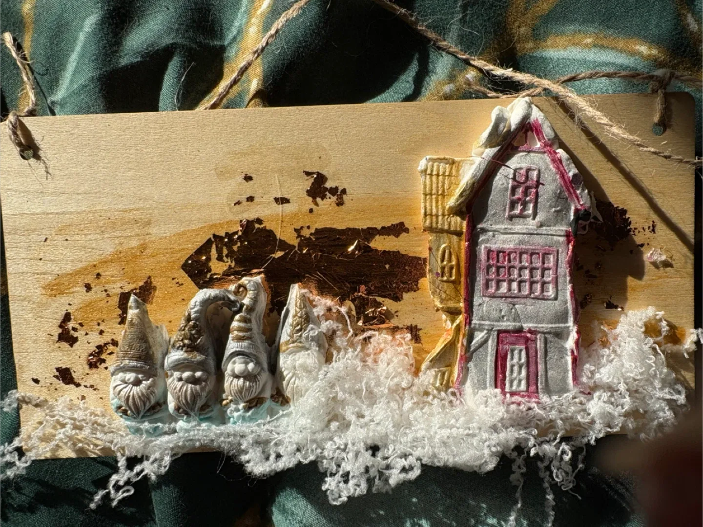 A wooden placard featuring a winter scene