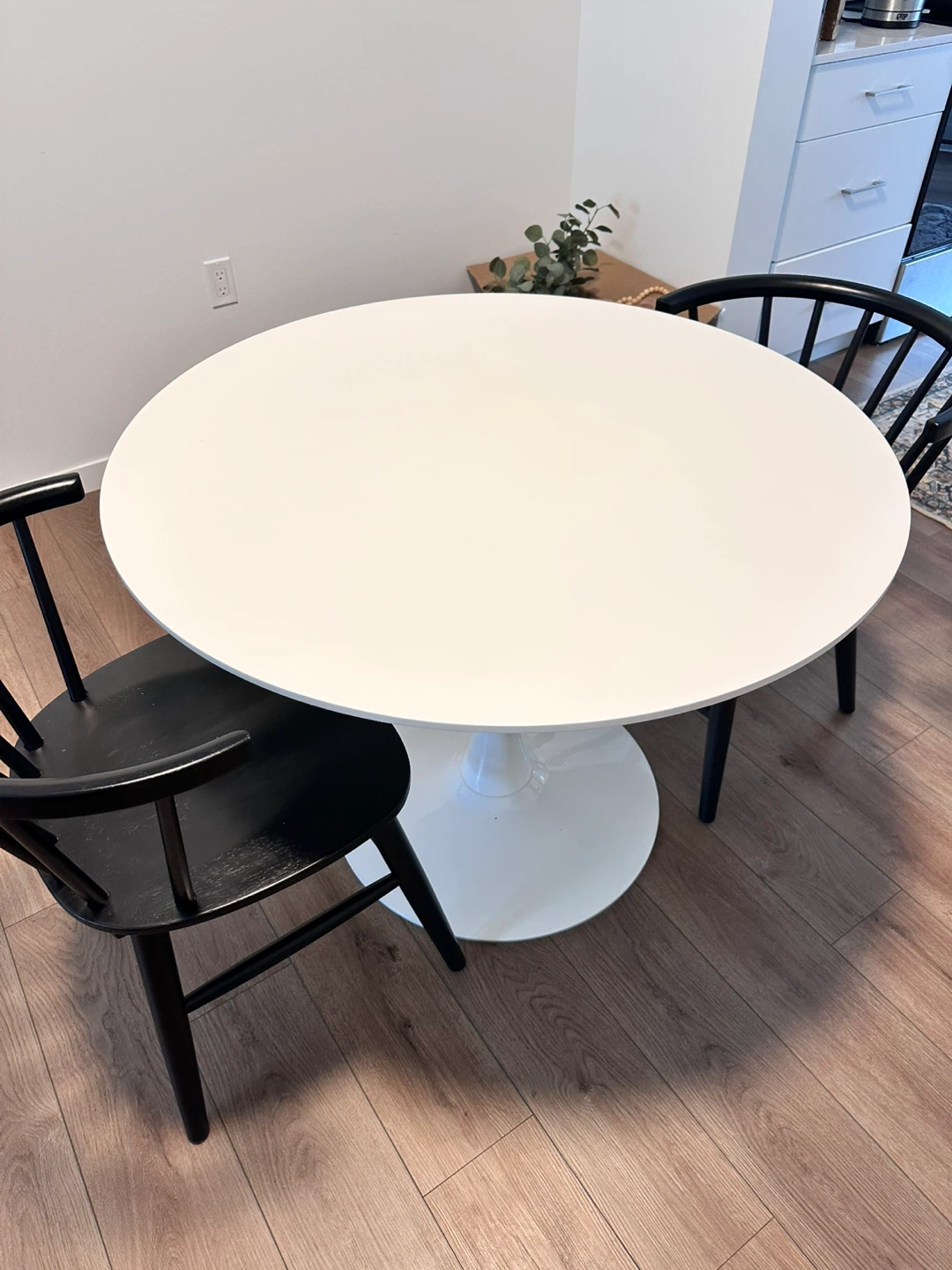 Round White Tulip Table with Black Chairs